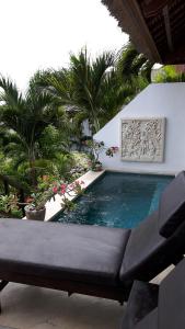 蓝梦岛蓝梦岛阿塔斯别墅的一个带沙发和棕榈树的游泳池