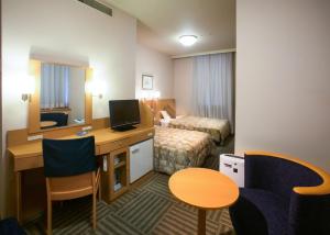 山形市山形邑西口华盛顿酒店的酒店客房配有书桌和床。