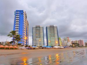 通苏帕Departamento Frente al Mar Diamond Beach的海滩上一群高大的建筑,上面有遮阳伞