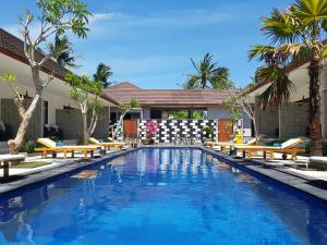 吉利特拉旺安松树别墅酒店的一个带长椅和棕榈树的游泳池