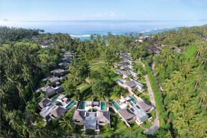 甘地达萨Candi Beach Resort & Spa的享有棕榈树和海洋度假村的空中景致