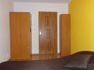 纳文丘夫Apartament na Nowickiego的一间卧室设有三张木橱柜和一张床