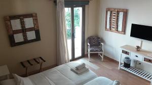卡拉纳雅达马贝尔酒店的一间卧室配有一张床、一台电视和一把椅子