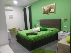 尼科洛西B&B La Grotta的绿色卧室配有一张带绿毯的床