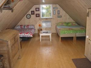 HagudiLonni Nature Eco-Accommodation的阁楼间设有两张床和一张桌子