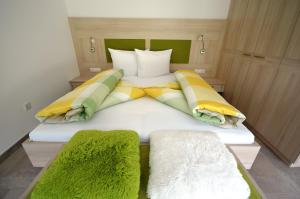 卡斯泰尔贝洛Panoramahof的一间卧室配有一张带绿色和黄色枕头的大床