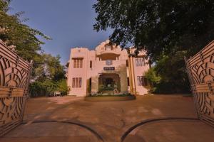 ChettinaduVisalam Chettinad Palace - CGH Earth的粉红色建筑的入口,有两个门