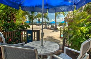 基拉戈Island Bay Resort的海滩上配有桌椅和遮阳伞