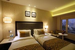 孟买萨赫勒酒店的酒店客房设有两张床和窗户。