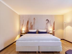 亚琛阿奎伊斯格拉德城市酒店的卧室配有带蓝色枕头的大型白色床