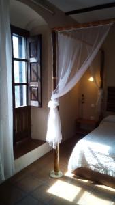 马尔帕尔蒂达德卡塞雷斯卡萨乡间玛丽亚旅馆的一间卧室设有一张床和一个窗口
