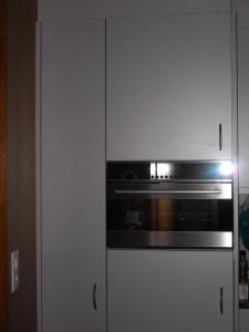 格林德尔瓦尔德帕芬斯托克利公寓的厨房配有炉灶和白色橱柜。