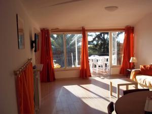 莱里奇Appartamento con vista sul Golfo的客厅配有红色窗帘,享有庭院的景色