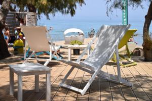 瓦西里科斯菲奥雷海滩一室公寓的海滩上的两把草坪椅和一张桌子