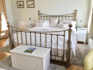 惠茨特布尔Cliftonville House的一间卧室配有一张带白色床单和一张桌子的床。