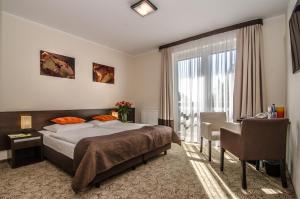 梅尔诺伊莫思雅SPA酒店的一间卧室配有一张床、一张书桌和一个窗户。