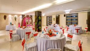 丹巴德Sonotel Hotels & Resorts Pvt Ltd的宴会厅配有白色的桌椅