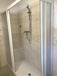 萨维尼奥内基娅拉酒店的浴室里设有玻璃门淋浴