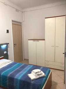 萨维尼奥内基娅拉酒店的一间卧室配有一张带蓝色床单和白色橱柜的床。