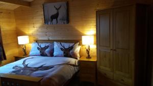 艾尔德里Lochinvar - Highland Log Cabin with Private Hot Tub的一间卧室,床上有三头鹿