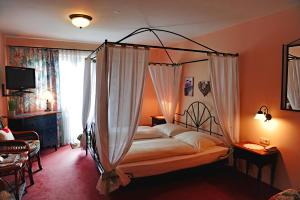 普夫龙滕Hotel Kienberger Hof的一间卧室,卧室内配有一张天蓬床