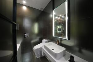 首尔天玺开浦酒店的一间带水槽、卫生间和镜子的浴室