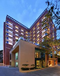 班加罗尔Welcomhotel by ITC Hotels, Richmond Road, Bengaluru的一座酒店大楼前面有棕榈树