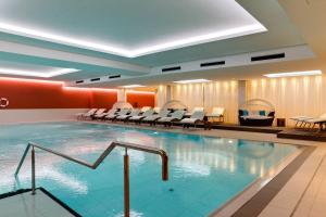 赛巴特班森SEETELHOTEL Kaiserstrand Beachhotel的酒店客房的大型游泳池配有椅子