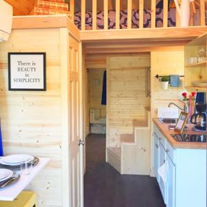 莱文沃思Leavenworth Camping Resort Tiny House Belle的一个小房子,设有厨房和楼梯
