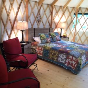 兰开斯特Circle M Camping Resort 16 ft. Yurt 1的蒙古包内带一张床和椅子的房间