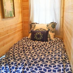 莱文沃思Leavenworth Camping Resort Tiny House Adeline的一间卧室配有一张带蓝色和白色棉被的床