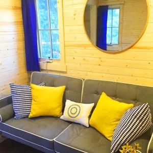 莱文沃思Leavenworth Camping Resort Tiny House Belle的一张配有黄色和白色枕头的沙发