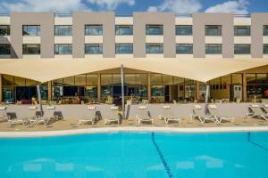 内罗毕罗望子树酒店的一座带游泳池和椅子的酒店和一座建筑