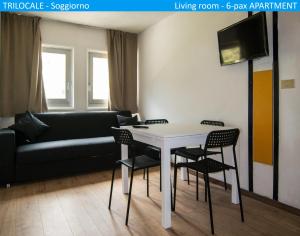 帕苏德尔托纳莱Apartment Tonale的客厅配有桌椅和沙发