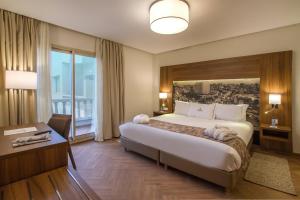 卡萨布兰卡美利博尔公寓式酒店的酒店客房设有一张大床和一张书桌。