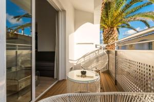 休达德亚Apartaments Cales de Ponent的阳台设有浴缸和棕榈树。