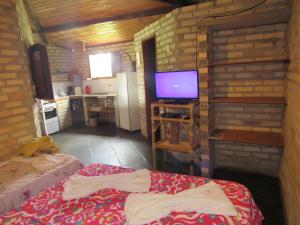 巴拉多库努Barravilha Chales的一间小房间,设有厨房和一台电视机