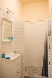 埃格尔Zora Apartman的白色的浴室设有水槽和淋浴。