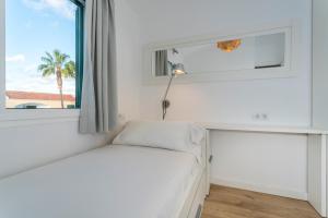 休达德亚Apartaments Cales de Ponent的窗户客房内的一张白色床
