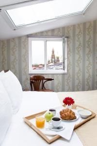 圣彼得堡莫卡5号酒店的床上的盒装早餐食品,有窗