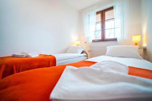 卡尔帕奇Apartament Mięta的橙色和白色的客房内的两张床