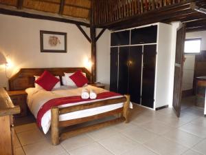 克龙斯塔德Boskoppie Lion & Tiger Reserve的一间卧室配有一张床,并备有2个拖鞋