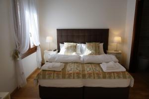 威尼斯霍图斯住宿加早餐旅馆的一间卧室配有一张大床和两条毛巾