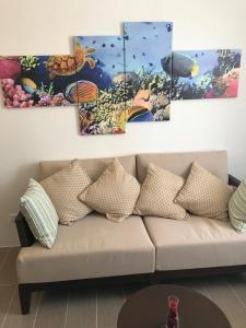 长滩岛2E C海滨大道公寓 - 长滩岛新海岸的客厅设有沙发,墙上挂有四幅画作
