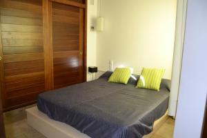 休达德亚Casa Fayas的一间卧室配有一张带两个绿色枕头的床