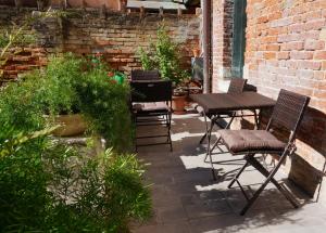 威尼斯霍图斯住宿加早餐旅馆的庭院配有桌椅和一些植物