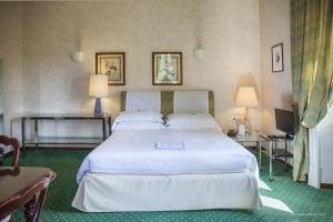 罗马阿尔德罗万迪城市套房酒店的卧室配有一张白色的大床和两张桌子