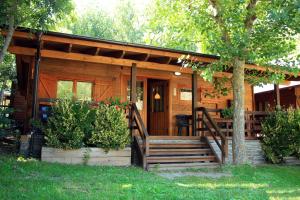 金格塔诺坎普露营简易别墅的小屋设有门廊和庭院内的长凳