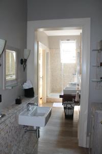 吕贝克Ferienwohnung Bamberger的白色的浴室设有2个水槽和1台钢琴