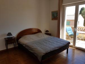 圣罗兰度瓦Villa Calliste的一间卧室设有一张床和一个大窗户